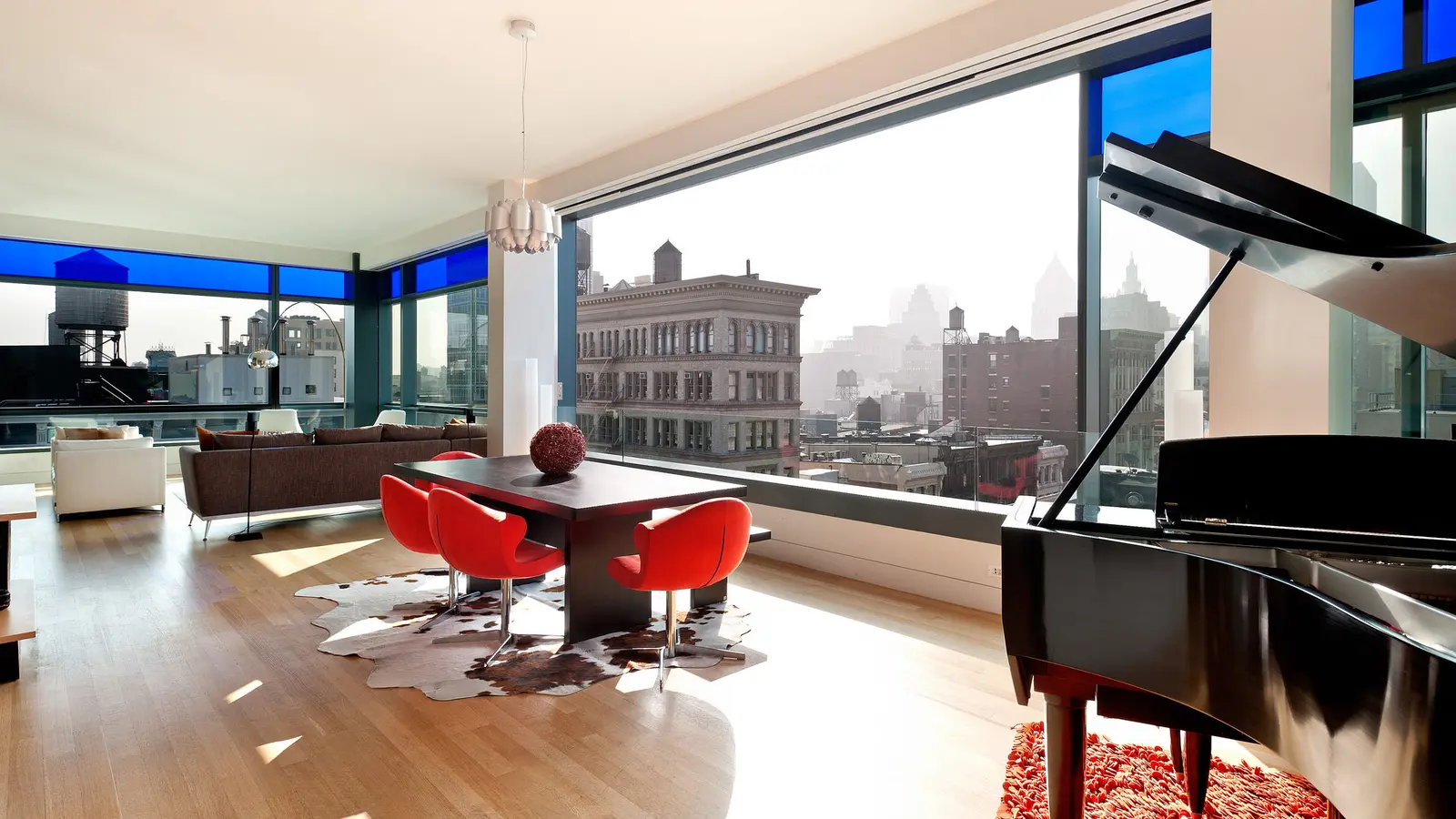 Sun-filled corner living room with floor-to-ceiling blue-tinted glass