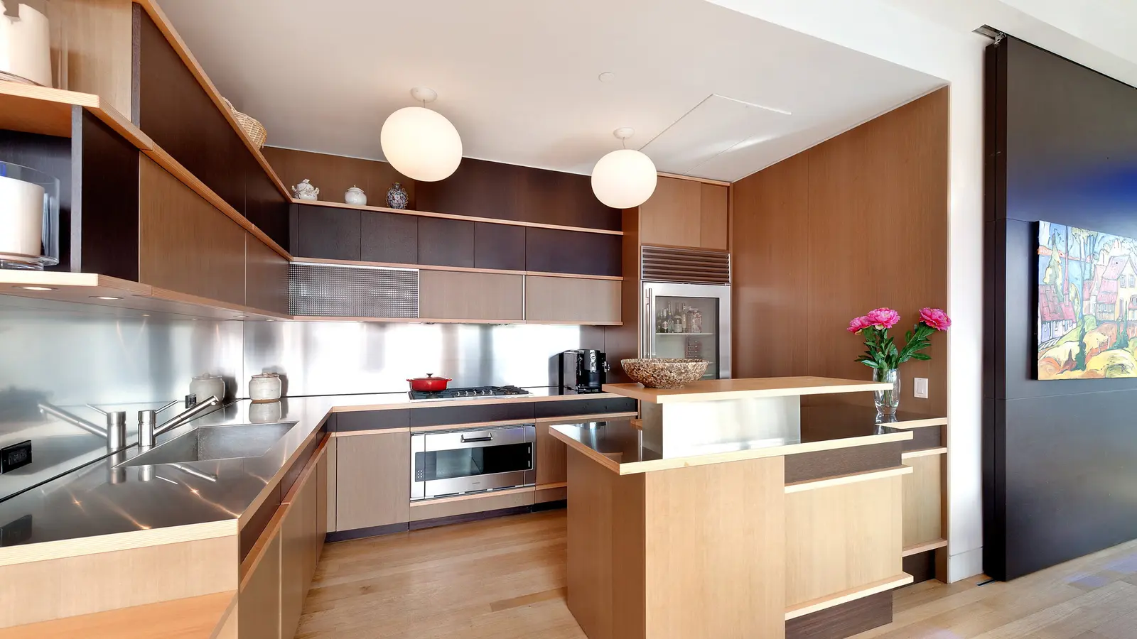 Teak-and-stainless-steel chef's kitchen with marble backsplash